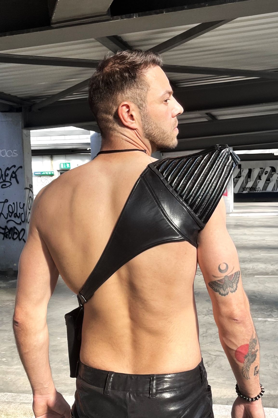 Humero Top – black glossy patent leather holster harness with vertical ribbed detailing, back view