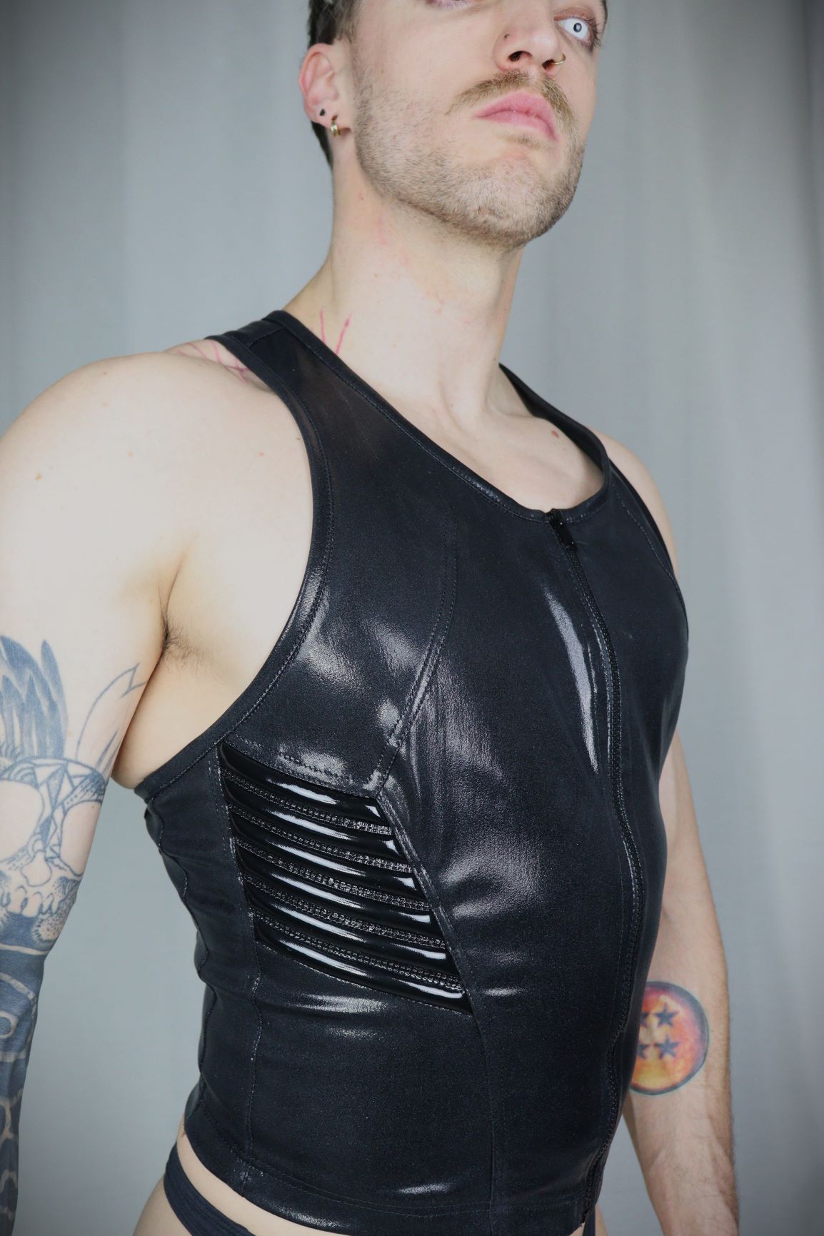 Serratus Top – glossy black leatherette sleeveless top with side-panel lacing, three-quarter view