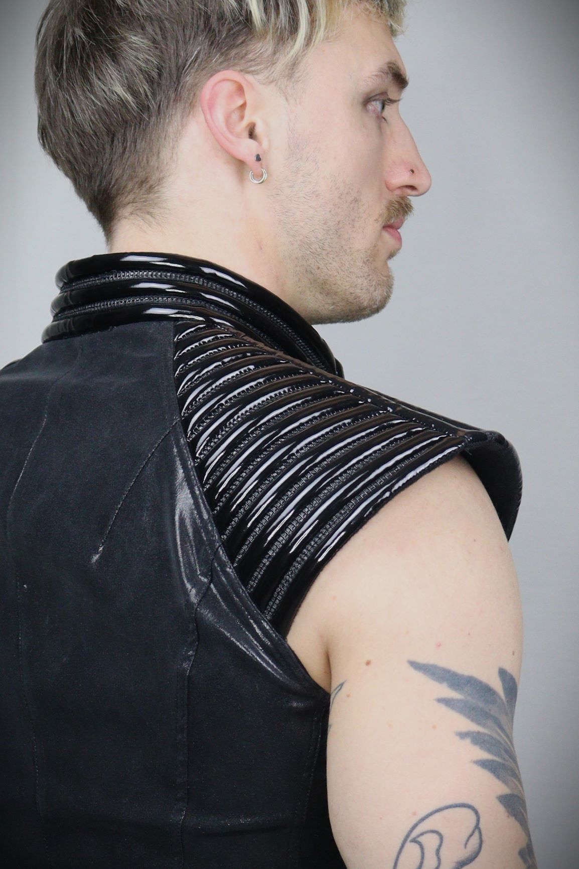 Thorax Top – glossy black leatherette sleeveless top with ribbed shoulder panels, side view