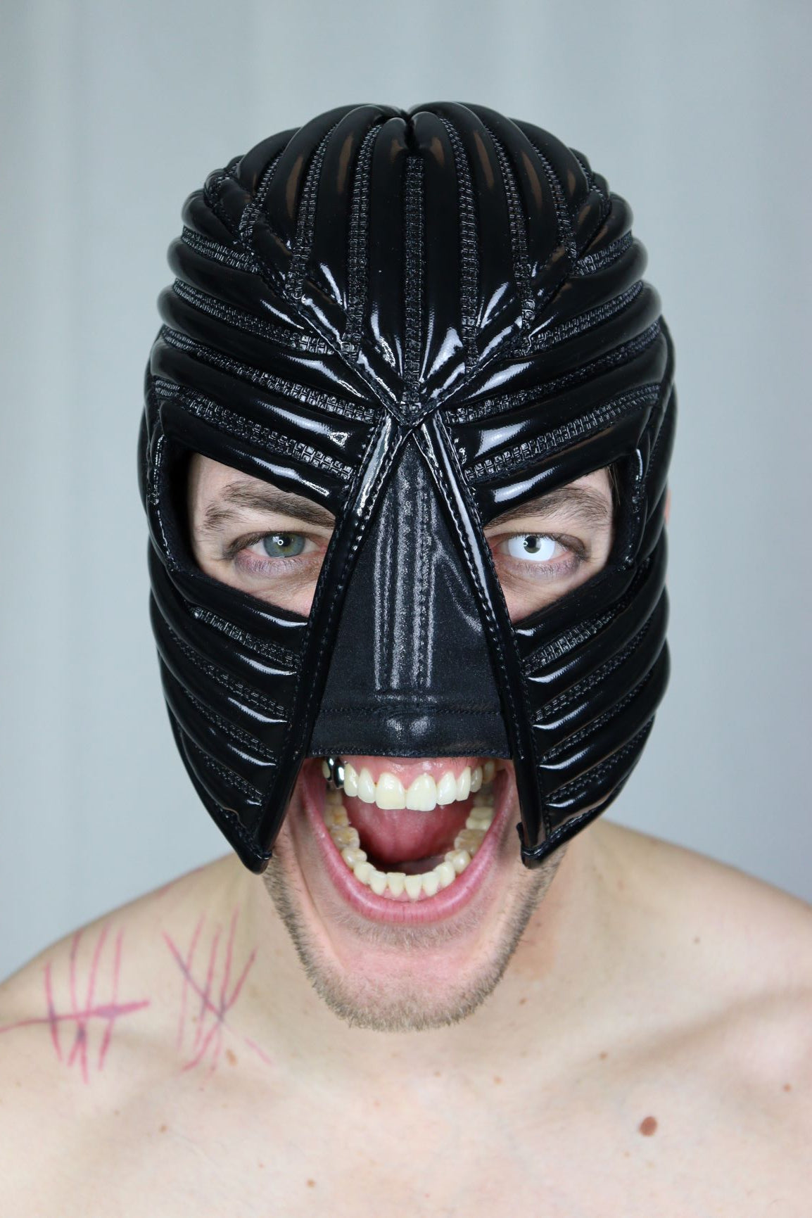 Warrior Mask – glossy black PVC with radiating ribbed crown structure, front view