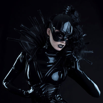 Comtesse DK – glossy black latex outfit with sculptural headpiece, three-quarter view