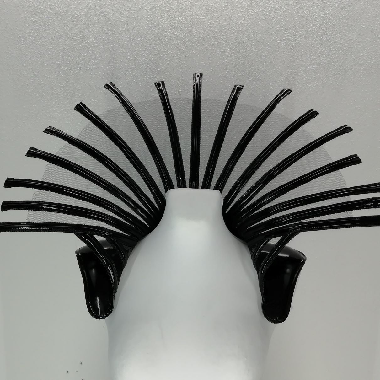 Comtesse DK – sculptural glossy black latex headpiece with spiky fan tendrils, front view